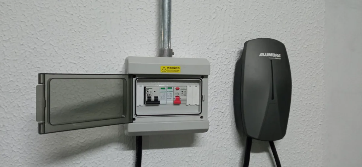 Quadro elétrico de proteção com disjuntor e DR ao lado de carregador de veículo elétrico